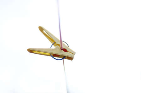Yellow clothes peg on a washing lineの写真素材