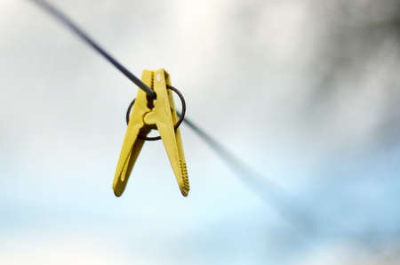 Closeup of Colorful clothes peg on a rope isolated on light backgroundの写真素材