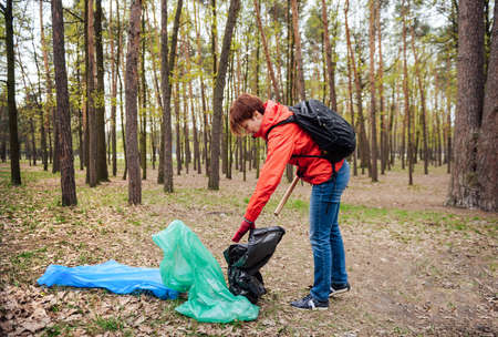 Woman volunteer collecting garbage in parkの写真素材