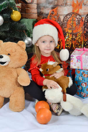 Cute little girl in Santa Claus hat with Christmas presentsの写真素材