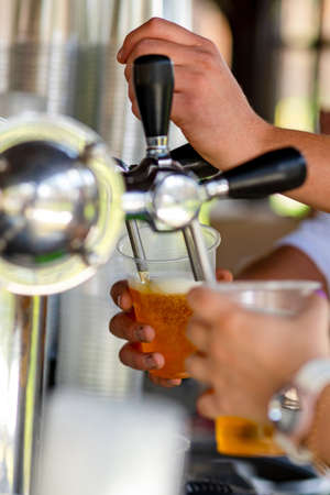 Close up on waiters hands serving beer pintsの写真素材