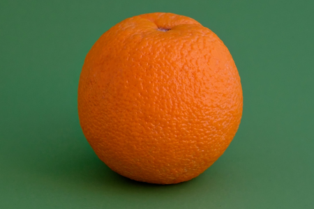 Picture of orange fruit isolated on green backgroundの写真素材