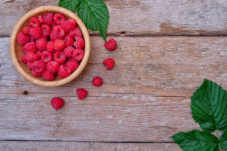 Organic raspberries on wood background. Top view