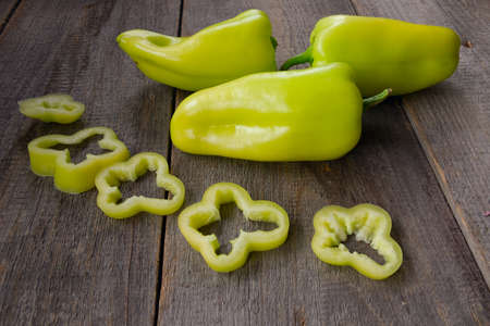 Photo of sliced green bell peppers over wooden table. Close upの写真素材