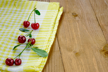 Six cherries on the yellow napkin. Wooden table backgroundの写真素材