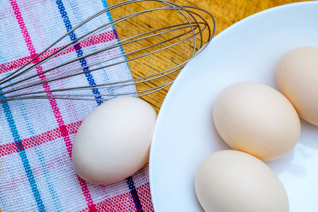 Fresh raw organic chicken eggs on red white checkered napkinの写真素材