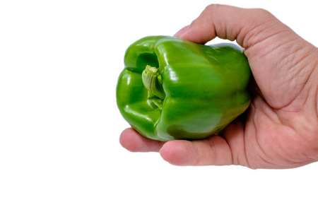 Hand holding greeb pepper isolated on white background