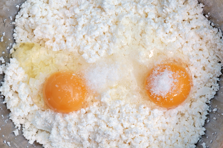 Cottage cheese, two eggs and salt close-up background. Top Viewの写真素材