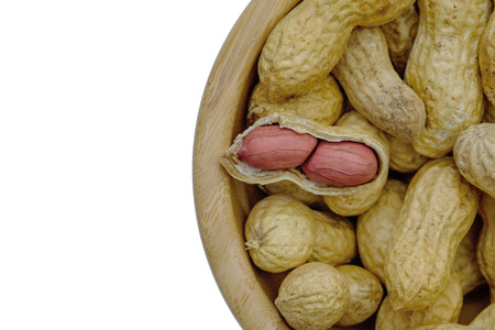 Dried peanuts in wooden bowl isolatd on white background. Close up