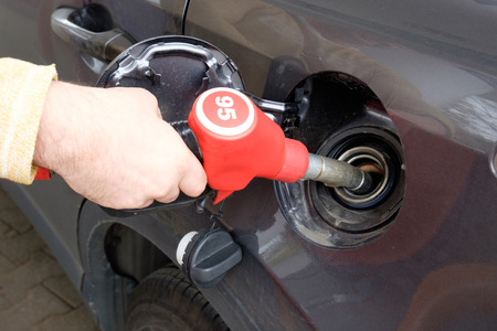Male hand refilling the car with fuel on a filling station