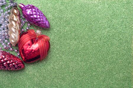 Christmas toy bump and christmas heart shaped red ball on green background. Empty space for textの写真素材