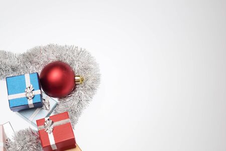 Small boxes for christmas gift, christmas balls and christmas tinsel on white background, Empty space for textの写真素材