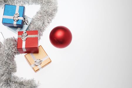 Small boxes for christmas gift, christmas balls and christmas tinsel on white background, Empty space for textの写真素材