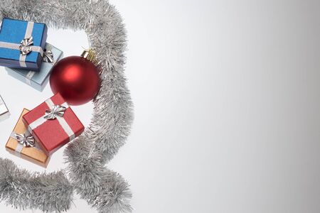 Small boxes for christmas gift, christmas balls and christmas tinsel on white background, Empty space for textの写真素材