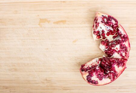 Broken red ripe juicy pomegranates on wooden table. Top View.の写真素材