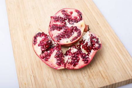 Broken red ripe juicy pomegranates on wooden table. Selective focusの写真素材