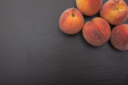 Ripe Peach ion black background of slate or stone.の写真素材