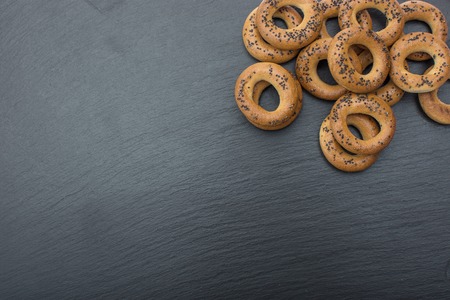 A dry bagels on black background of slate or stone.の写真素材