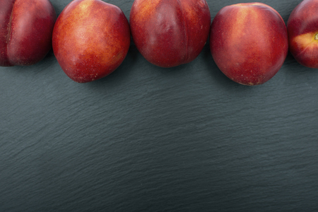 Ripe nectarine on black background of slate or stone. Free space for your textの写真素材