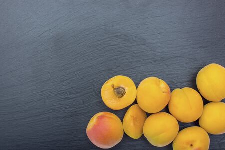 Ripe apricot on black background of slate or stone. Free space for textの写真素材