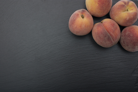 Ripe Peach ion black background of slate or stone.の写真素材