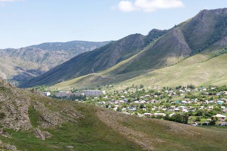 View of the village of Asubulak, Kazakhstan. Beautiful clouds over the village surrounded by mountains. Summer timeの写真素材