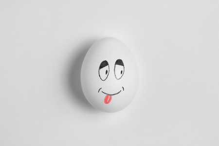 Egg cute smiling on a white background. Drawing on the eggの写真素材