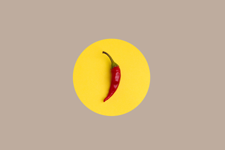 Red chili pepper on yellow background