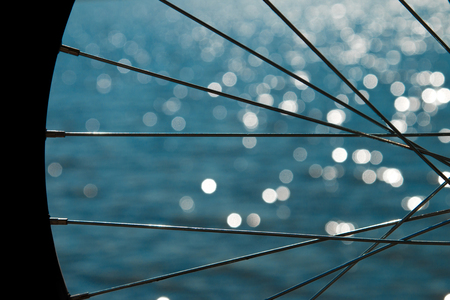 Bicycle wheel on the background of the sea. Bicycle wheel spokesの写真素材