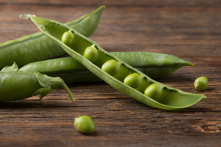 Fresh green pea pod on a wooden backgroundの写真素材