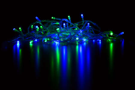 The light of the colored lights of the garland in the darkness