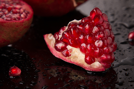 A piece of fresh pomegranate on a dark backgroundの写真素材