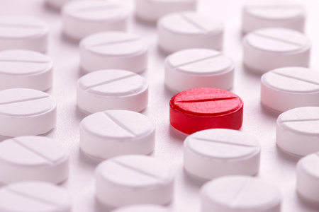 Red tablet among white. Medical conceptの写真素材