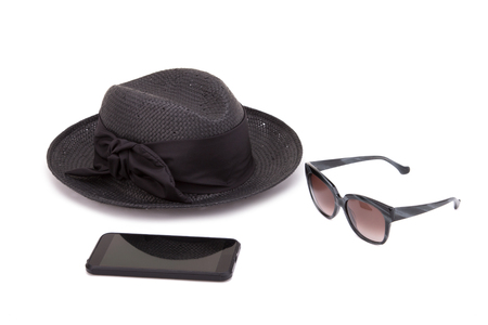 Hat, sunglasses and smartphone on a white backgroundの写真素材