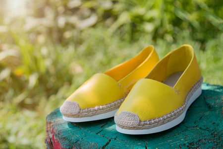 Espadrilles against a background of green grass. Fashionable yellow espadrilles.の写真素材