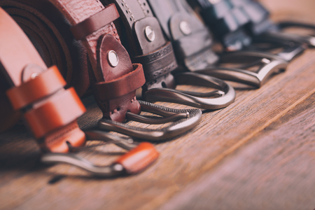 Leather belts lying on a wooden tableの写真素材