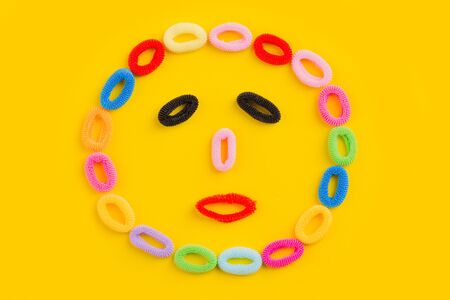 Colored hair ties on a yellow background.の写真素材