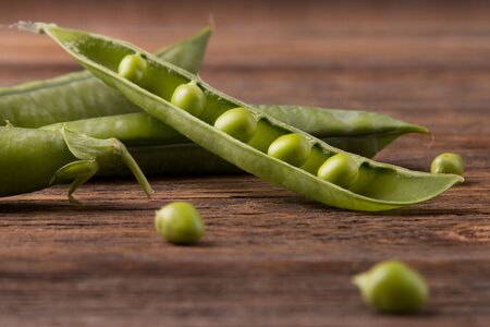Green peas on wooden background.の写真素材