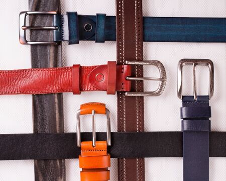 Colored leather belts on a white background.の写真素材