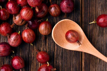 Berries of red gooseberry close-up. Gooseberries on a wooden table.の写真素材
