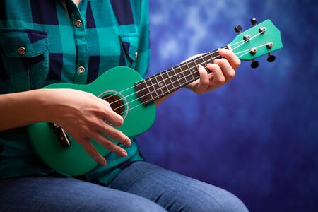 The girl plays a small ukulele.の写真素材