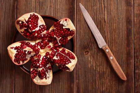Opened pomegranate on a wooden table.の写真素材