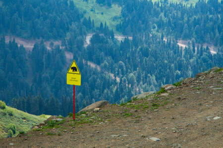 Sign caution wild animals in the mountains. Wild bear sign.