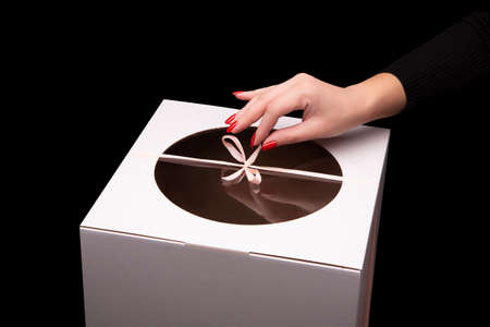 The girl opens a gift box. Ribbon bow on the box.