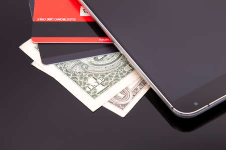 Smartphone, bank card and paper banknotes.