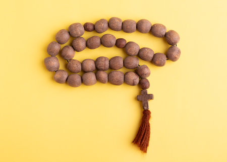 Wooden rosary on a yellow background.の写真素材