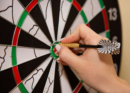 The girl plays darts. Dart darts in the hands of a girl.