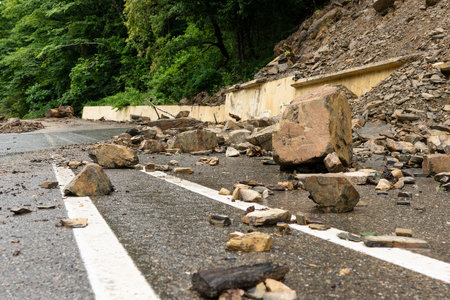 Rockfall on the road. Large rocks of rock fell on the asphalt road.の写真素材