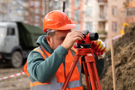 Surveyor worker with theodolite equipment at construction site