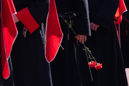 A red carnation flower in the hands of a Cossack warrior.